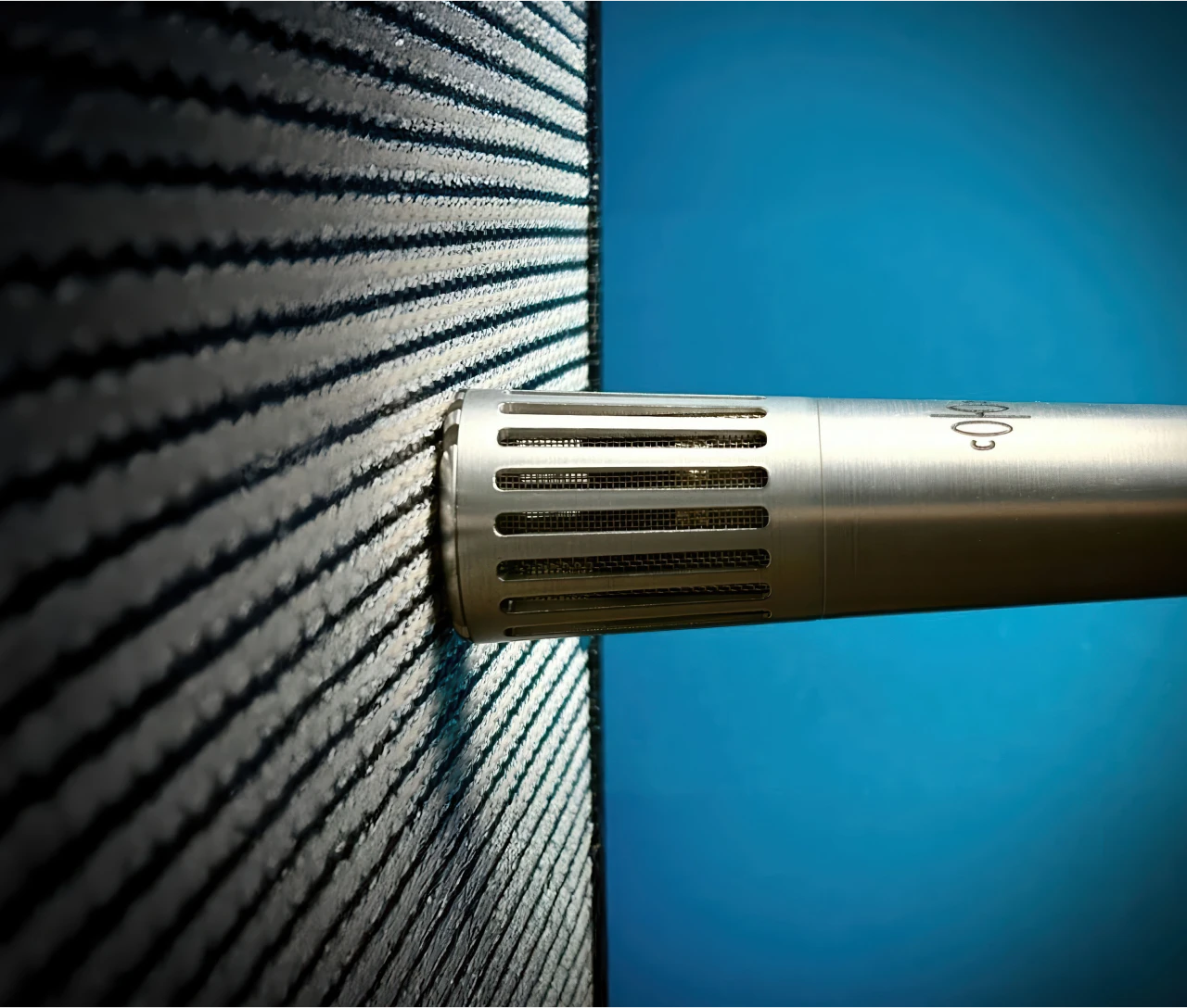 Soyuz V1 Dynamic Microphone in professional studio setting with acoustic foam panels and blue lighting